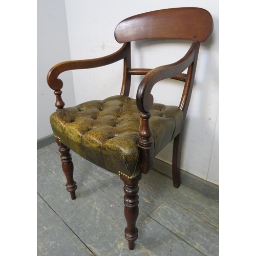 711 - An early Victorian mahogany desk chair upholstered in antique buttoned brown leather with brass stud... 