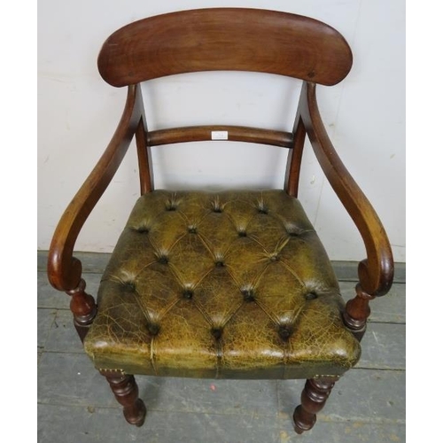 711 - An early Victorian mahogany desk chair upholstered in antique buttoned brown leather with brass stud... 