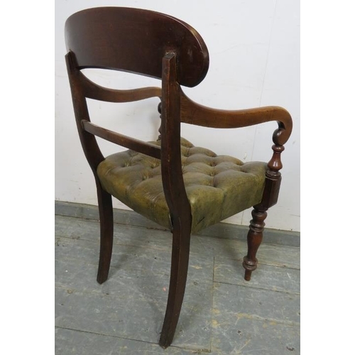 711 - An early Victorian mahogany desk chair upholstered in antique buttoned brown leather with brass stud... 