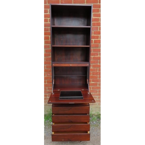 714 - A mid-century Danish hardwood tall drinks cabinet, having three open shelves above a fall-front mixi... 