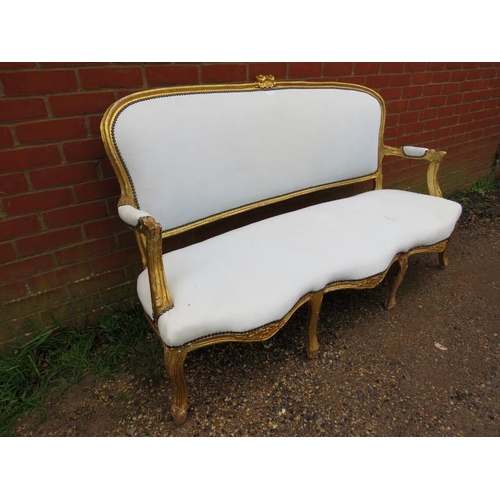 716 - A 19th century French giltwood three-seater sofa, having a serpentine front, reupholstered in calico... 