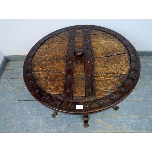 721 - A low circular coffee table fashioned from a medieval cartwheel with iron strapwork mounts, on a bes... 