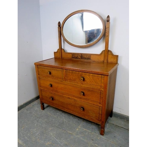 724 - An Art Deco Period medium oak dressing chest, the bevelled oval swing mirror above a base housing tw... 