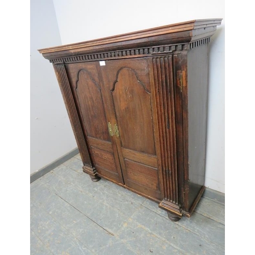 730 - A 17th century and later enclosed bookcase, having dentil cornice above panelled doors flanked by fl... 