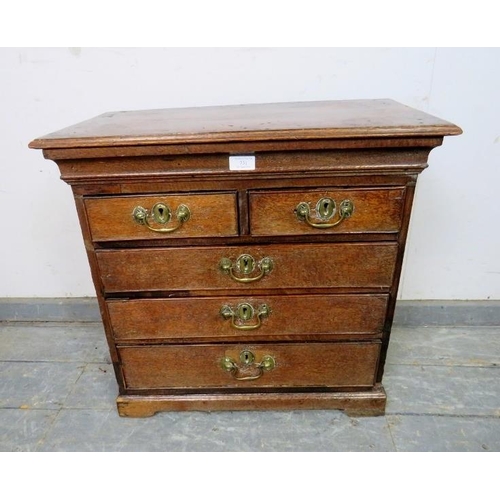 731 - A diminutive 18th century oak chest, housing two short over three long graduated cock-beaded drawers... 