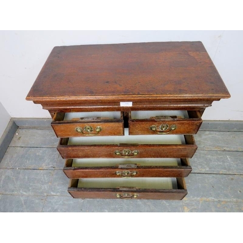 731 - A diminutive 18th century oak chest, housing two short over three long graduated cock-beaded drawers... 