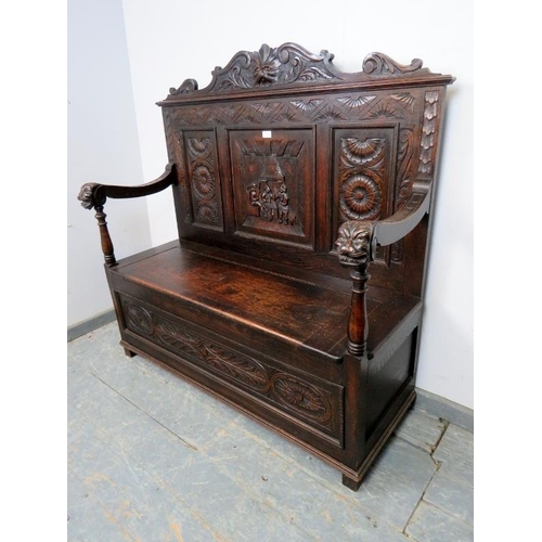 735 - A 19th century Gothic Revival oak settle, the backrest with relief carved decoration depicting taver... 