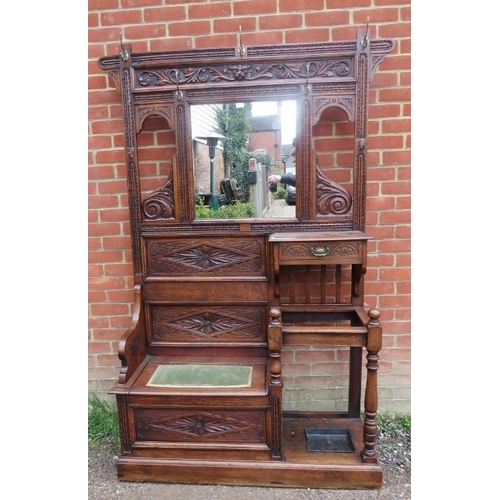 740A - A 19th century Gothic Revival oak hallstand with relief carved acanthus decoration, having an array ... 