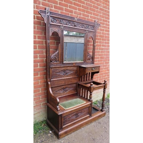 740A - A 19th century Gothic Revival oak hallstand with relief carved acanthus decoration, having an array ... 