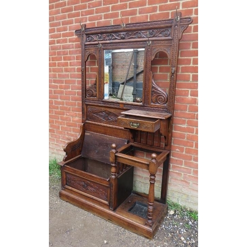 740A - A 19th century Gothic Revival oak hallstand with relief carved acanthus decoration, having an array ... 