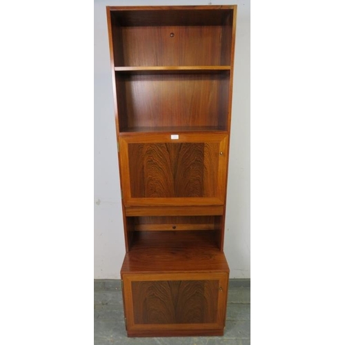 748 - A mid-century tall narrow tropical hardwood bookcase by Omman Jun, having two open shelves above cro... 