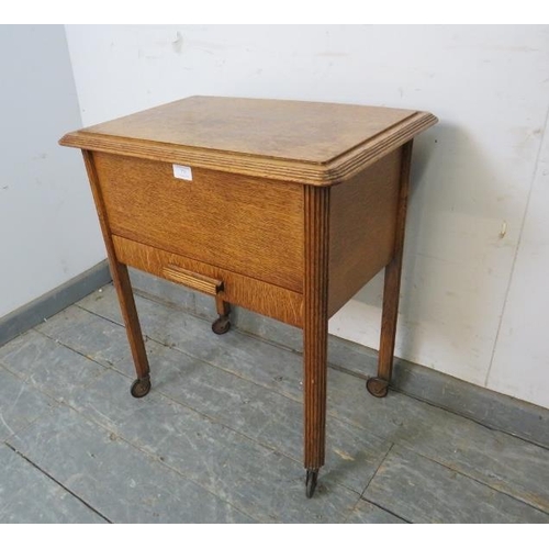 773 - An Art Deco Period medium oak sewing box, having a silk lined storage well above one long drawer, on... 