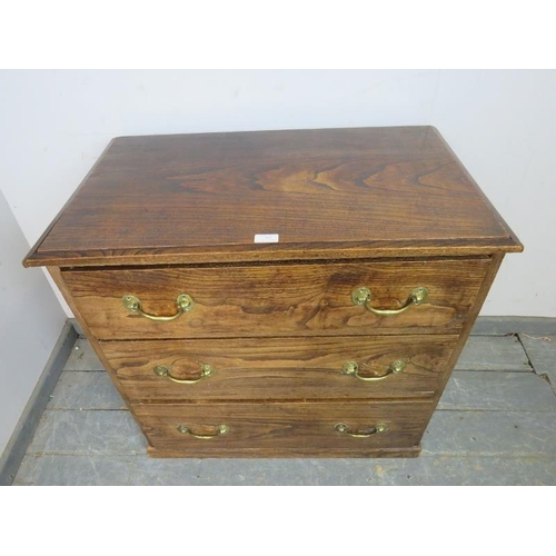 783 - An antique elm chest, housing three graduated long drawers with brass bail handles, on a plinth base... 