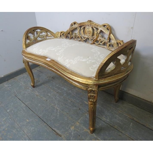 785 - An antique French kidney shaped giltwood window seat, having ornately carved and pierced back and si... 