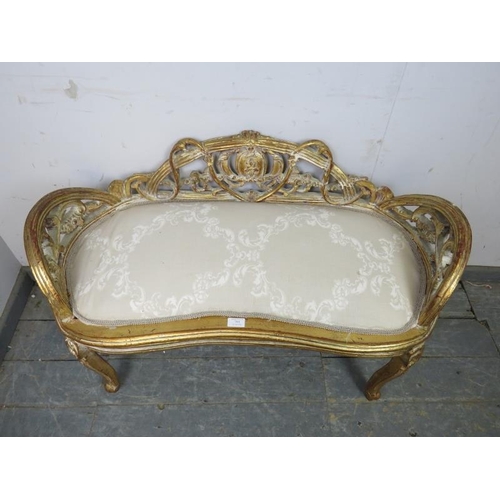 785 - An antique French kidney shaped giltwood window seat, having ornately carved and pierced back and si... 