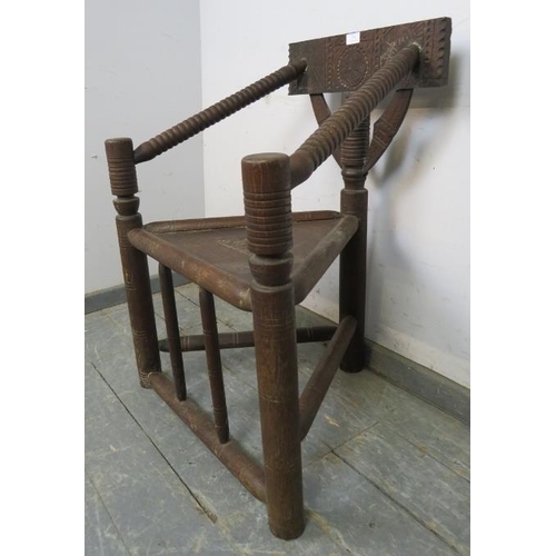 795 - A vintage African hardwood tribal chieftain’s chair, having a carved back rest joined with bobbin tu... 