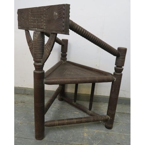 795 - A vintage African hardwood tribal chieftain’s chair, having a carved back rest joined with bobbin tu... 