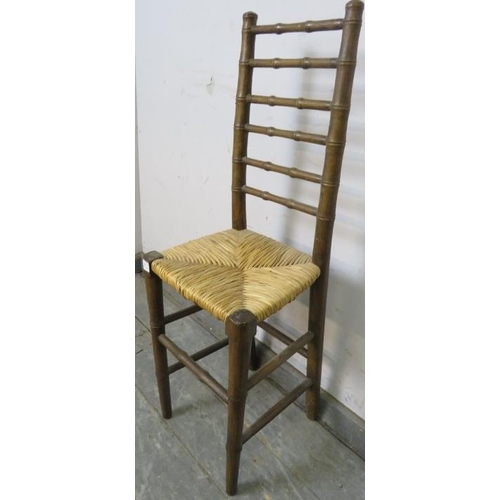 801 - A 19th century faux bamboo ladderback child’s correctional chair, having a rush seat, on tapered sup... 