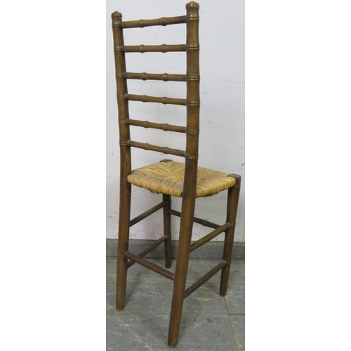 801 - A 19th century faux bamboo ladderback child’s correctional chair, having a rush seat, on tapered sup... 