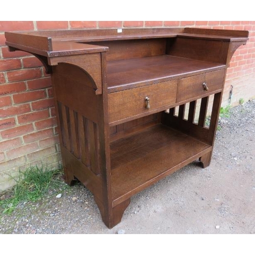 814 - An Arts & Crafts oak buffet sideboard by Liberty & Co, having a ¾ shelved gallery above two short dr... 