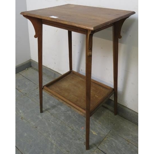 815 - An Arts & Crafts walnut two-tier occasional table, having shaped corner brackets, on canted tapering... 