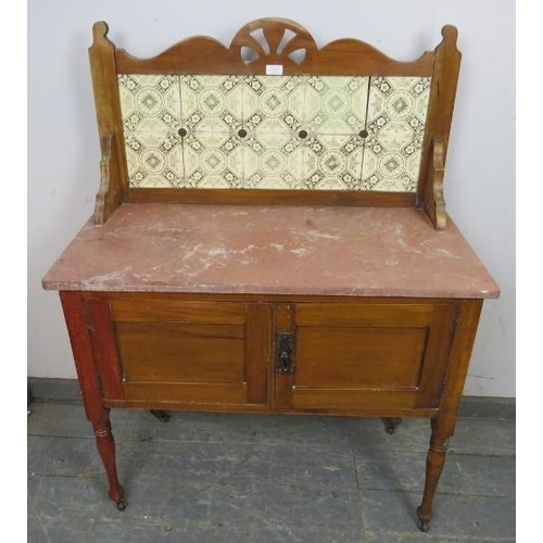 827 - A turn of the century walnut washstand, the rear gallery with inset tiles, above a rouge marble top,... 