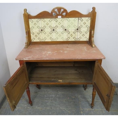 827 - A turn of the century walnut washstand, the rear gallery with inset tiles, above a rouge marble top,... 