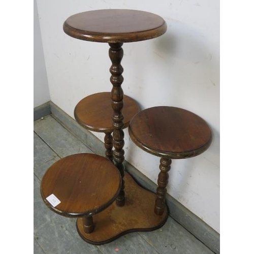 828 - A vintage mahogany asymmetrical four tier display/plant stand with bobbin turned uprights, on a tref... 