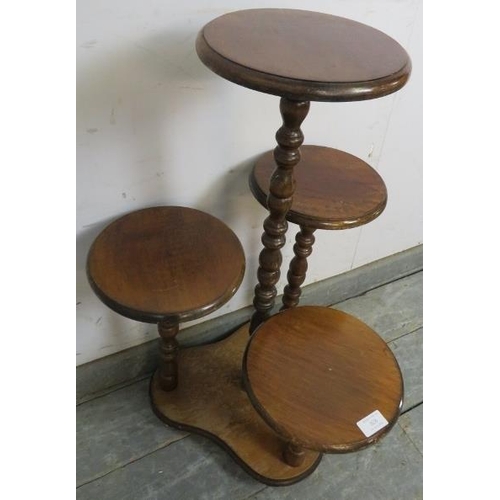 828 - A vintage mahogany asymmetrical four tier display/plant stand with bobbin turned uprights, on a tref... 