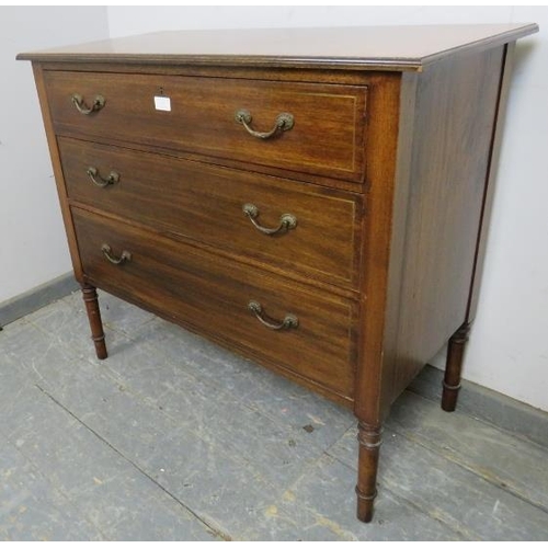 843 - An Edwardian mahogany chest housing three long drawers with fancy brass handles and inlaid brass ban... 