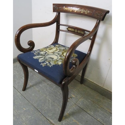 855 - A Regency Period mahogany sabre leg elbow chair, the carved back with brass inlay, joined with scrol... 