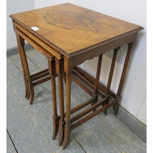 857 - A nest of three antique walnut graduated tables, the quarter veneered tops on turned supports with s... 