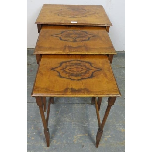 857 - A nest of three antique walnut graduated tables, the quarter veneered tops on turned supports with s... 