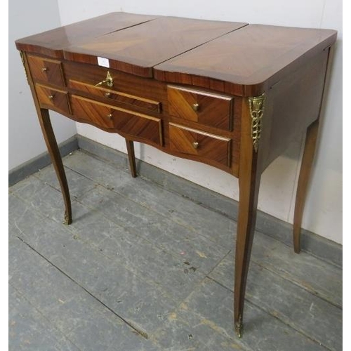 863 - A vintage French mahogany and tulipwood dressing table with gilt brass mounts, the rising central mi... 