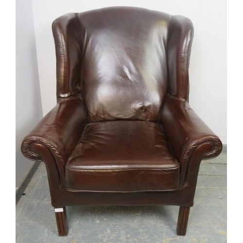 870 - An antique style wingback armchair, upholstered in brown leather, on reeded square supports.
H115cm ... 