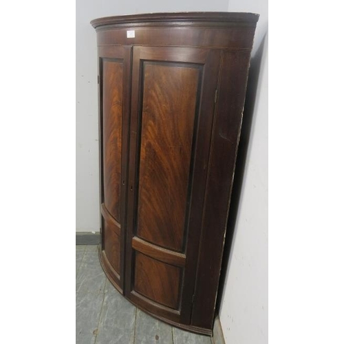 878 - A George III flame mahogany bow-fronted hanging corner cupboard with ebony and boxwood inlay, the pa... 