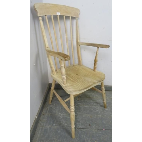 879 - An antique stripped elm and beech Windsor fireside chair, on canted turned supports with an ‘H’ stre... 