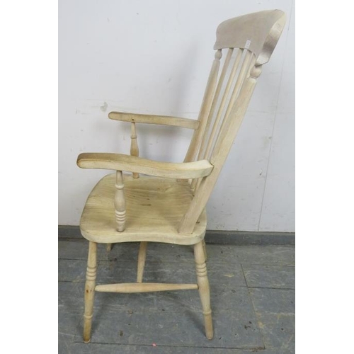 879 - An antique stripped elm and beech Windsor fireside chair, on canted turned supports with an ‘H’ stre... 