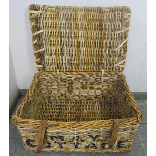 883 - An antique wicker laundry basket, with handles to either side and leather fastening straps, emblazon... 