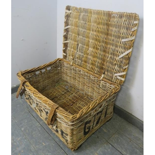 883 - An antique wicker laundry basket, with handles to either side and leather fastening straps, emblazon... 