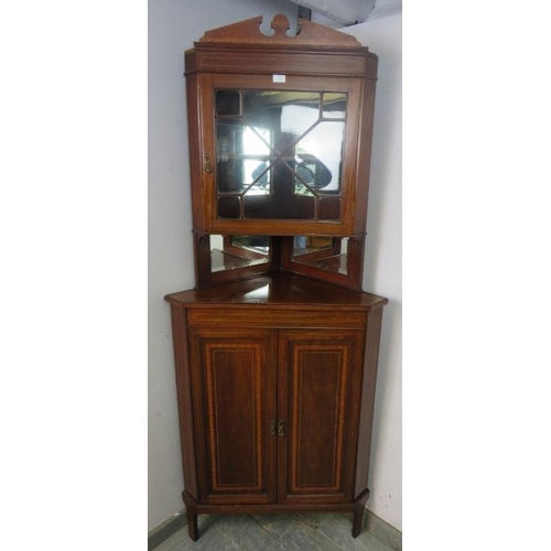 886 - An Edwardian mahogany tall corner cupboard, crossbanded and parquetry strung, the top section with a... 