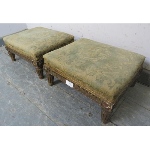 891 - A pair of Regency Period giltwood footstools, retaining the original upholstery, on fluted supports ... 