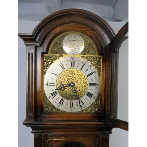 893 - A vintage oak cased ‘Tempus Fugit’ chiming longcase clock, the arched dial enclosed by ornate brass ... 