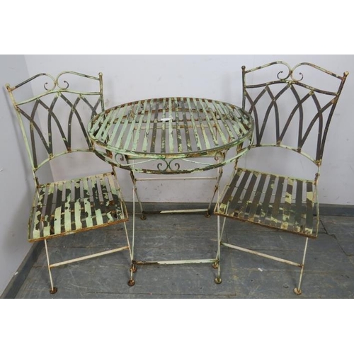 895 - A vintage garden set painted pale green, comprising two folding chairs with slatted seats and a circ... 