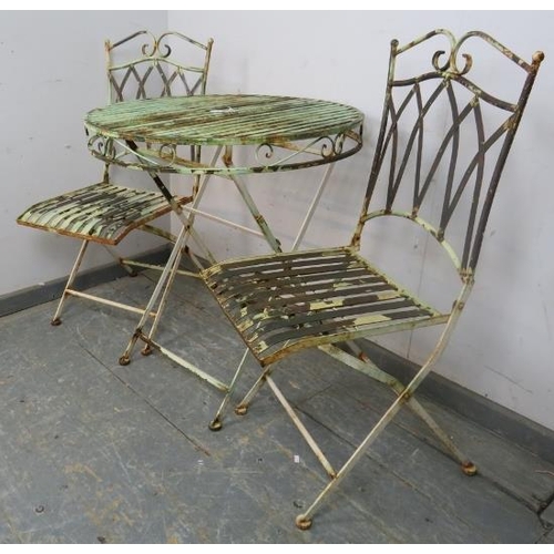 895 - A vintage garden set painted pale green, comprising two folding chairs with slatted seats and a circ... 