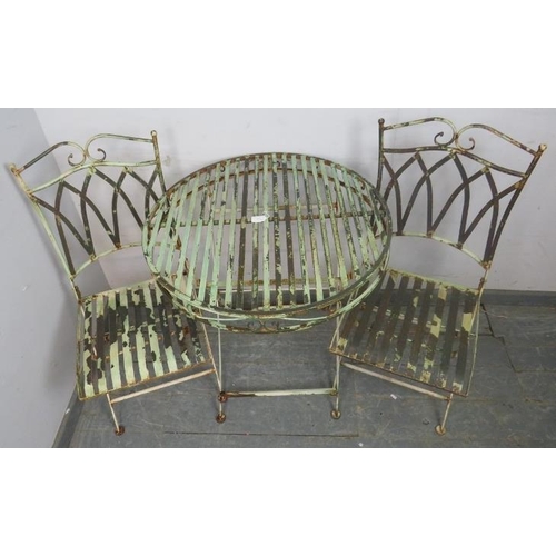 895 - A vintage garden set painted pale green, comprising two folding chairs with slatted seats and a circ... 