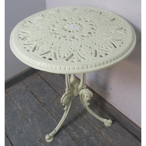 896 - An antique cast iron circular garden table painted pale green, the pierced top on scrolled supports.... 