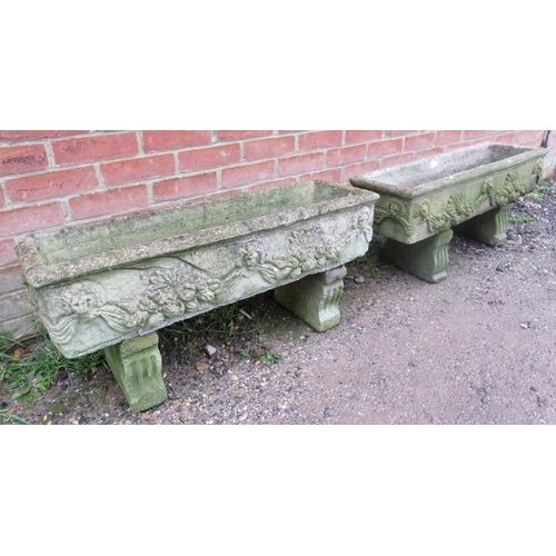 896A - A pair of weathered reconstituted stone trough planters, having relief decoration depicting lion mas... 