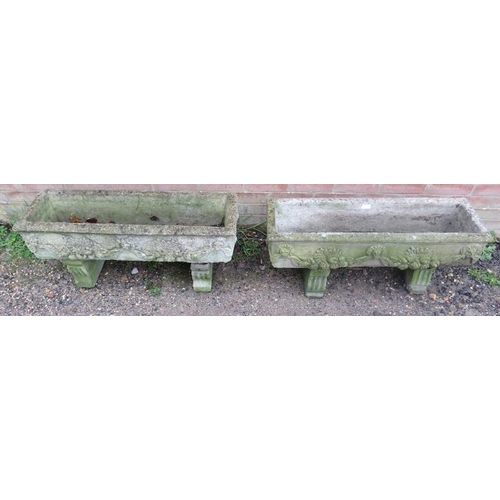 896A - A pair of weathered reconstituted stone trough planters, having relief decoration depicting lion mas... 