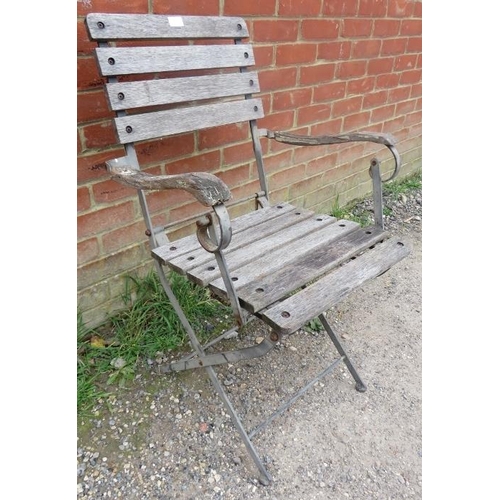 898 - A weathered teak folding garden elbow chair with slatted seat. 
H90cm W59cm D81cm (approx).
Conditio... 